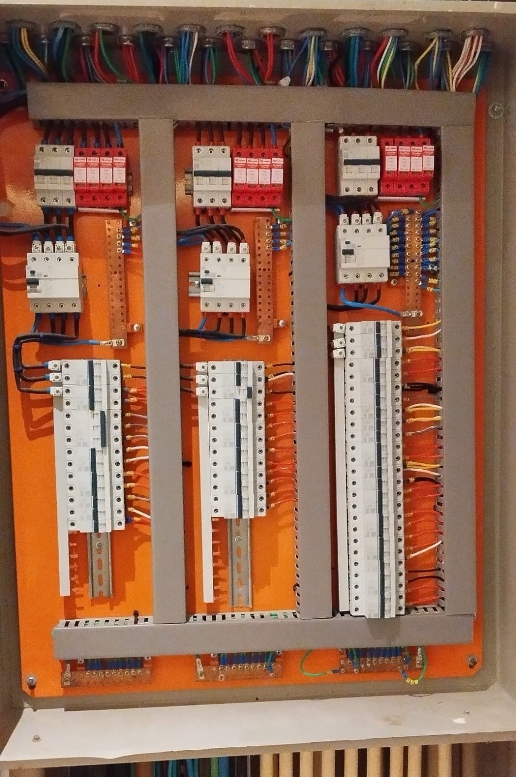 Quadro elétrico industrial aberto mostrando barramentos de cobre, bornes de distribuição e chegada de condutores por prensa-cabos na parte superior