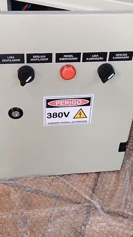 Frente do painel de comando 380 V com botoeiras identificadas, sinaleiro de painel energizado e placa de perigo